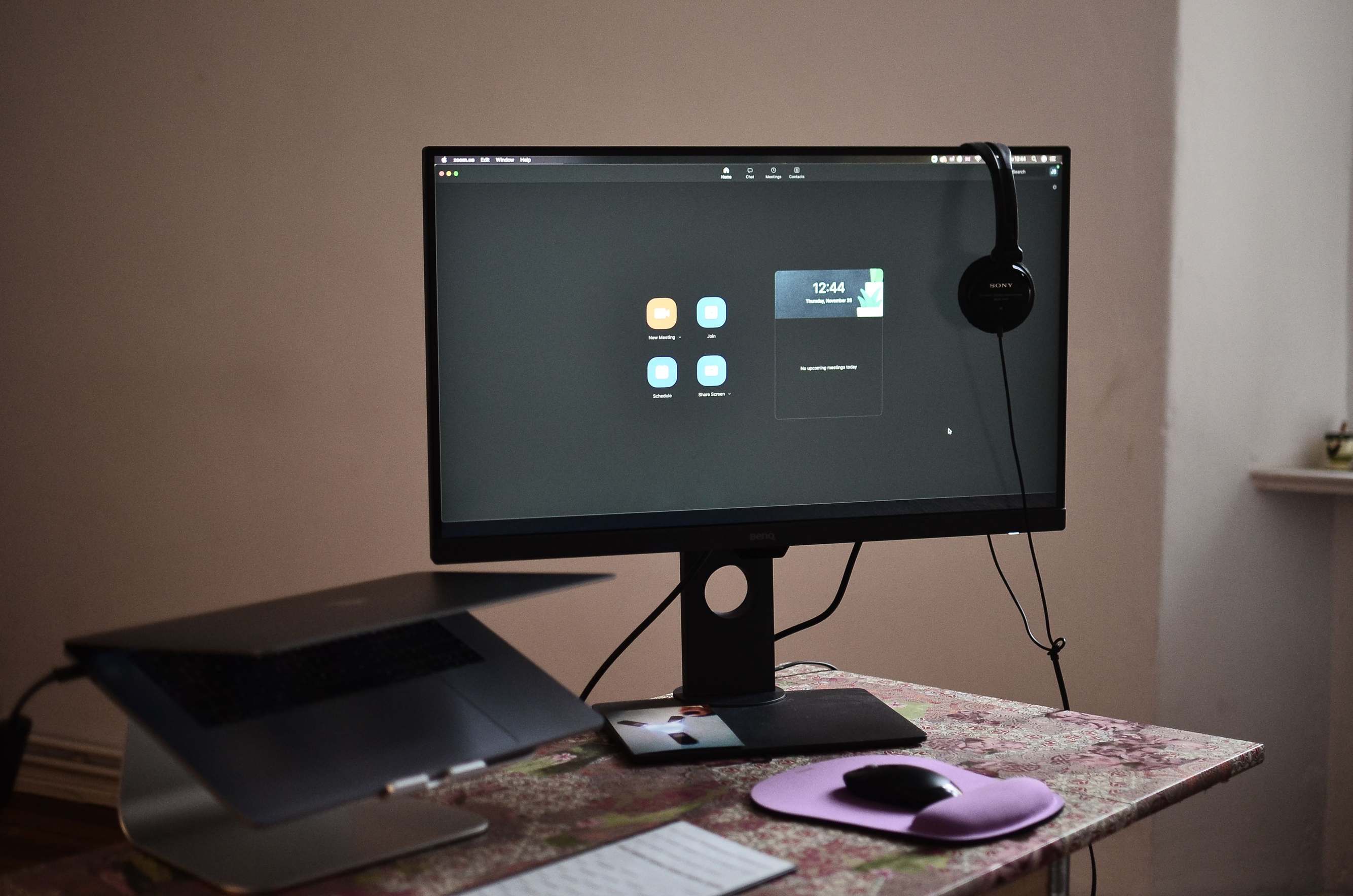 Laptop and external monitor on a desk with keyboard and mouse at a workplace
